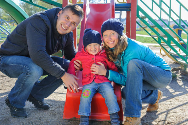 istock Parents with daughter playing at children's slide 687565720