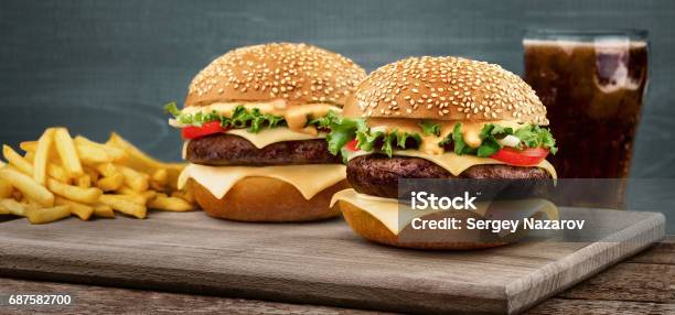 Two Craft Beef Burgers On Wooden Table On Blue Background Stock Photo - Download Image Now
