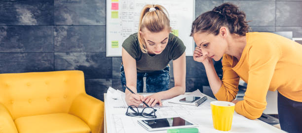 Two business woman checking blueprints