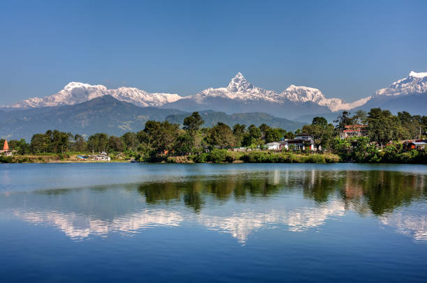 vista a la cordillera de annapurna y su reflejo en el lago phewa en pokhara, nepal - nepal fotografías e imágenes de stock