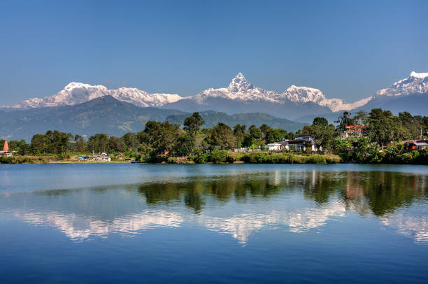 вид на горный хребет аннапурна и его отражение в озере фева в покхаре, непал - непал стоковые фото и изображения