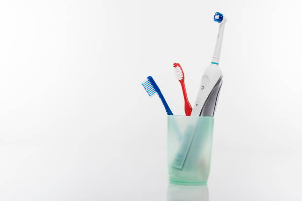 istock Electric and Manual Toothbrushes in One Cup Together. 687613610