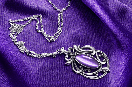 Vintage amethyst pendant on purple satin