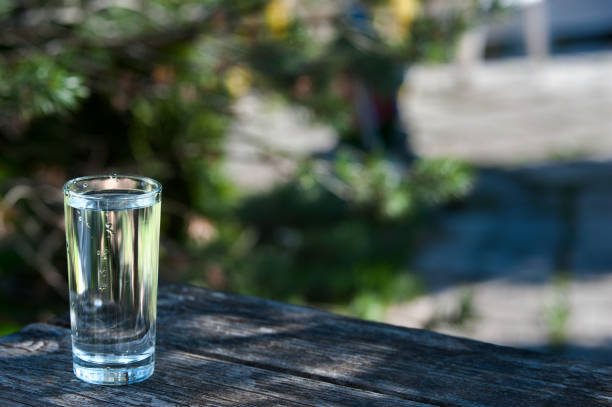 istock Glass with transparent, cool clean water on a green garden background. 687634962