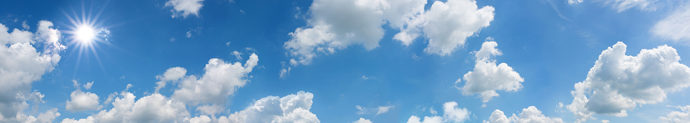 Blue sky panorama with sun and white clouds in summer