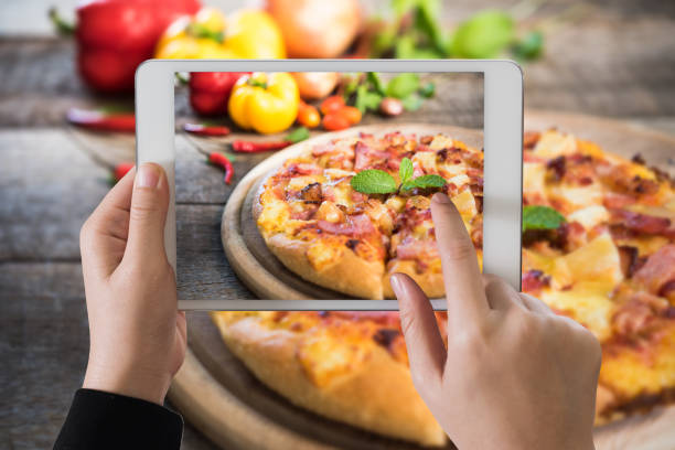 istock Digital tablet on delicious italian pizza on wooden table 687644362