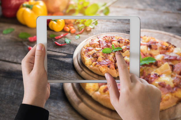 istock Digital tablet on delicious italian pizza on wooden table 687644366