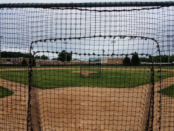 diamante da baseball con reti di sicurezza - baseball base baseball diamond field foto e immagini stock