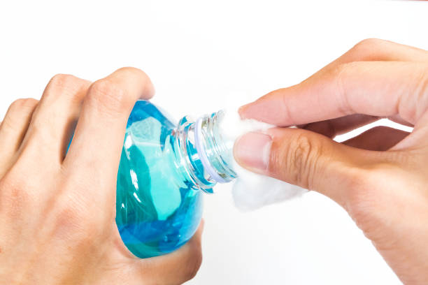istock man holding ethyl alcohol bottle and cotton ball 687656918