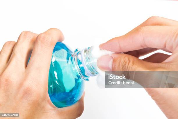 Man Holding Ethyl Alcohol Bottle And Cotton Ball Stock Photo - Download Image Now - Alcohol - Drink, Cotton, Bottle