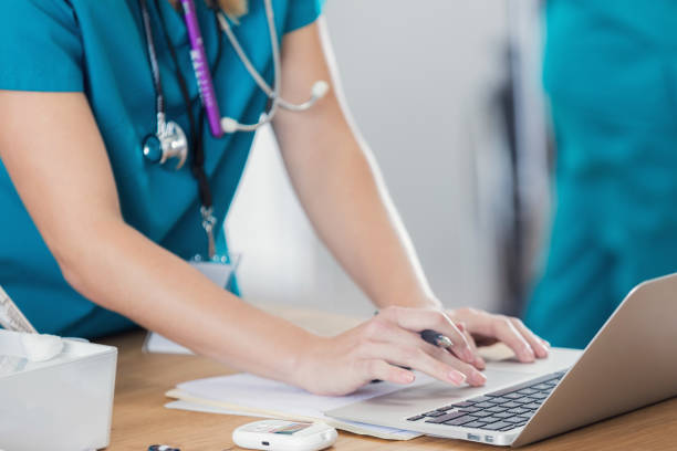 zuversichtlich krankenschwester nutzt laptop in arztpraxis - allgemeinarztpraxis fotos stock-fotos und bilder