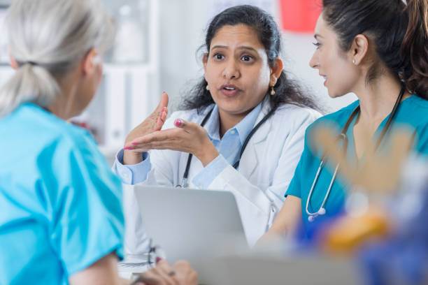 medico indiano discute qualcosa con lo staff medico - lab coat nurse doctor female doctor foto e immagini stock