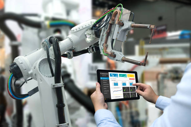 istock Engineer hand using tablet, heavy automation robot arm machine in smart factory industrial with tablet real time monitoring system application. Industry 4th iot concept. 687663970