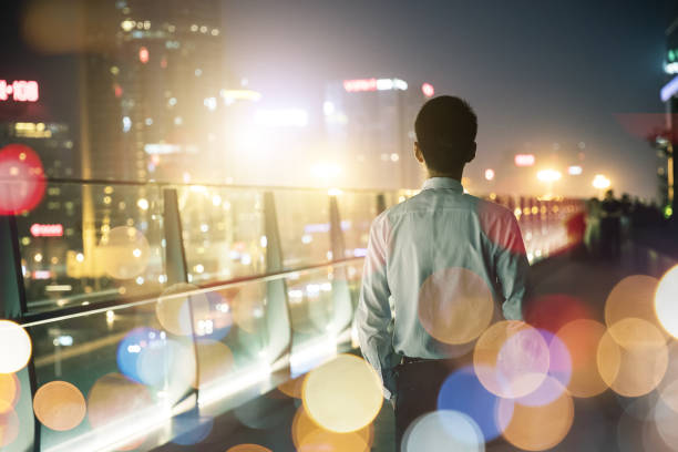 istock Businessman looking at city at night 687664080