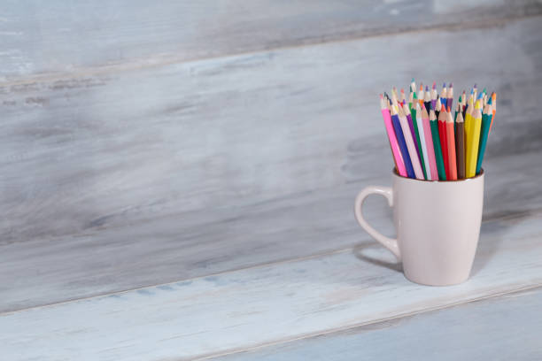 istock Stack of colored pencils in a glass on wooden background 687664462