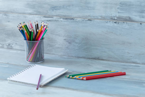 istock Notebook diary bright color pencils stationery on old wooden table vintage background 687667162