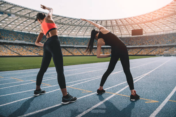 lekkoatletyczne młode kobiety w odzieży sportowej ćwiczące na stadionie na torze - stadium empty seat women zdjęcia i obrazy z banku zdjęć