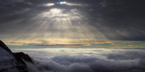 Rays of sunlight penetrating cloud cover in Slovenian mountains
