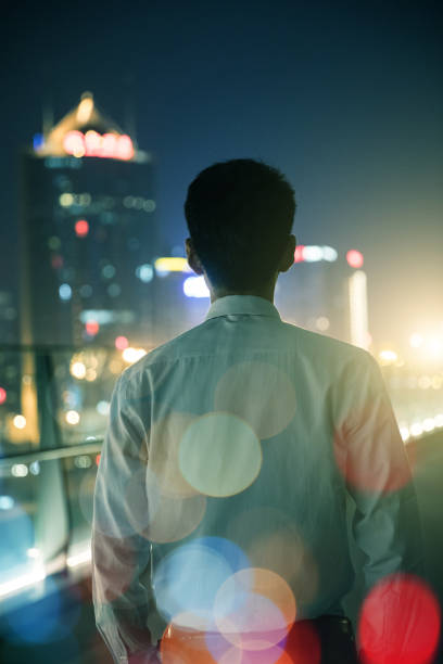 istock Businessman looking at city at night 687675068
