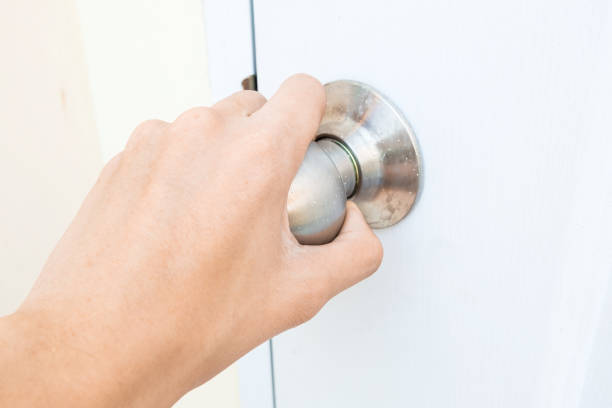 istock hand opening white door knob 687678198