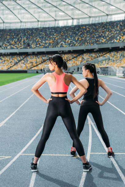 lekkoatletyczne młode kobiety w odzieży sportowej ćwiczące na stadionie na torze - stadium empty seat women zdjęcia i obrazy z banku zdjęć