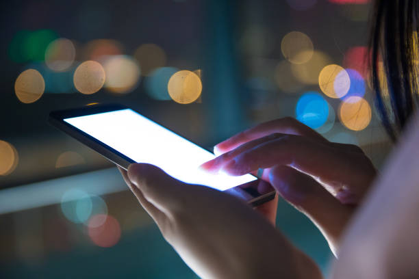 istock Hand holding mobile phone at night street 687680016