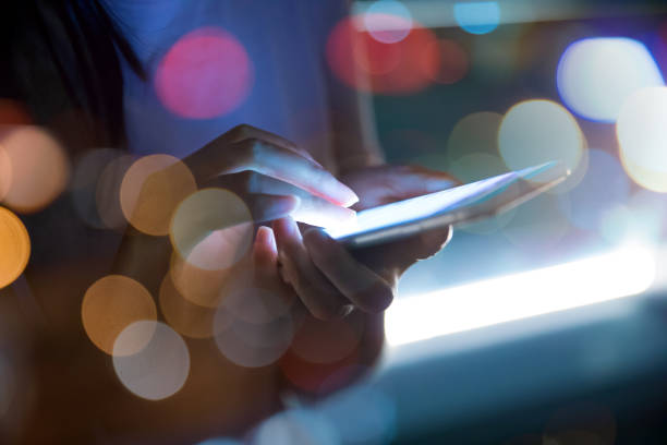 istock Hand holding mobile phone at night street 687685762