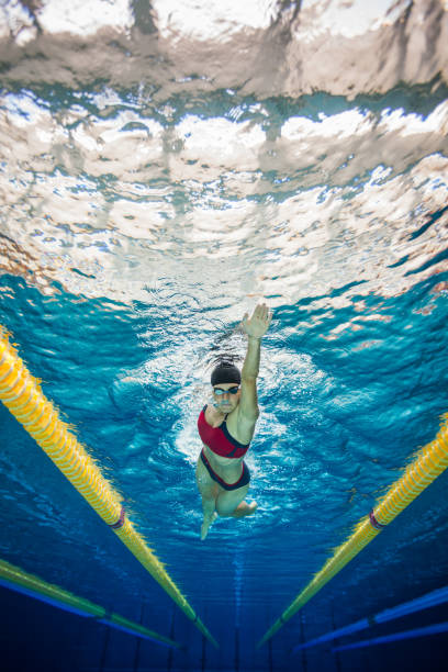 istock Women in Sport, vertical swimmer underwater 687686490
