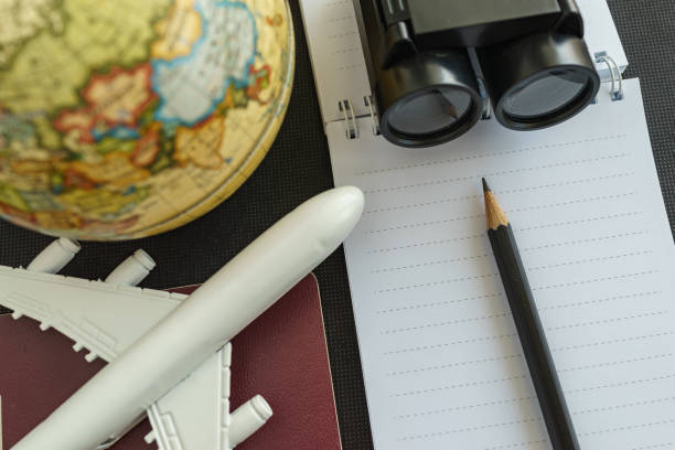istock World travel concept with toy airplane, pencil binoculars, passport, note and globe on black background 687686816