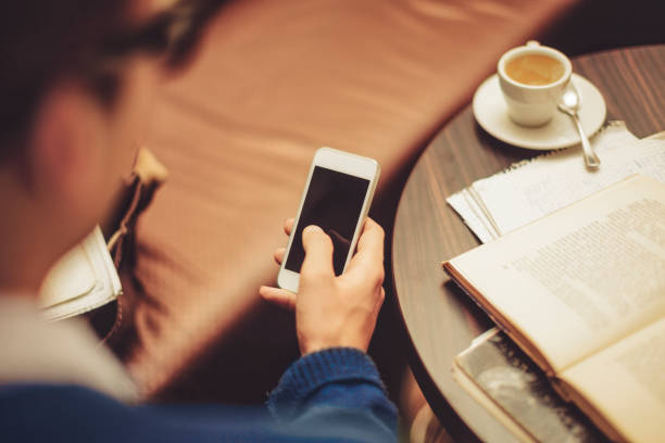 istock Young man drinking espresso and texting in a cafe 687687140