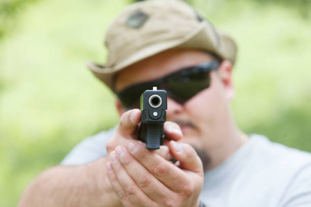 istock A man shoots a pistol. He looks at us 687692694