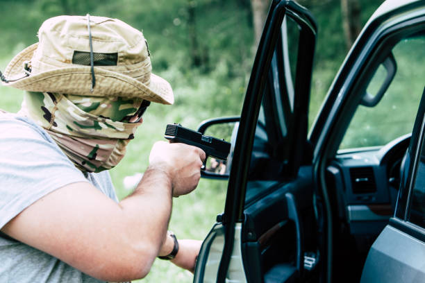 istock Man with a gun opens the car door 687694980