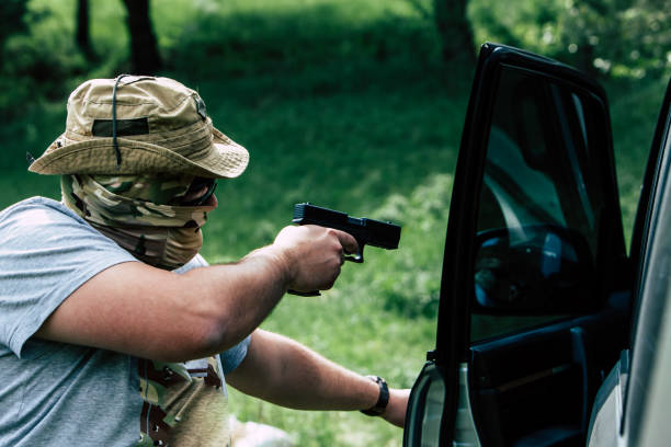 istock Man with a gun opens the car door 687695044