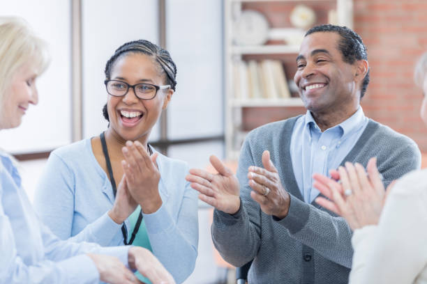 istock Colleagues applaud woman during meeting 687698420