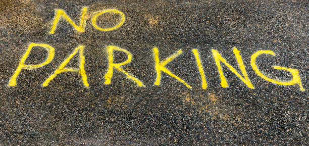 istock Yellow Hand Painted No Parking Sign on asphalt 687699042