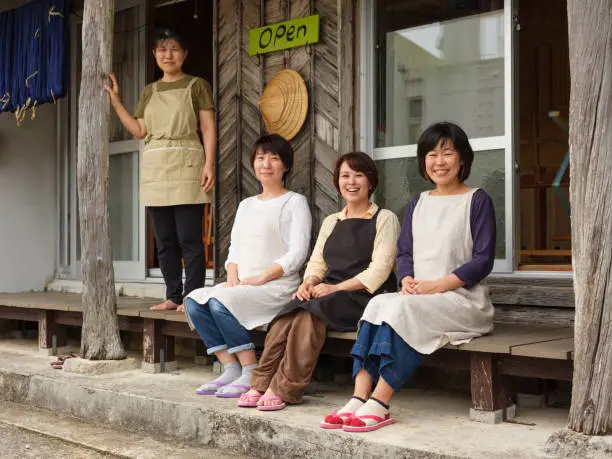 Japanese woman workers in a traditional Orimono textile shop in Okinawa, Japan.