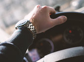 Close-up of man's hand on steering wheel. Vintage look. Shallow depth of field.