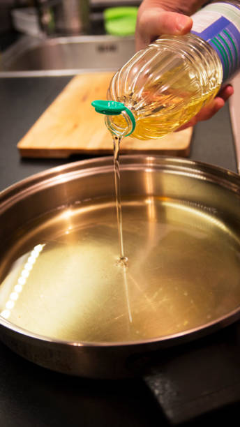 istock Pouring cooking oil into a pan. 687703374