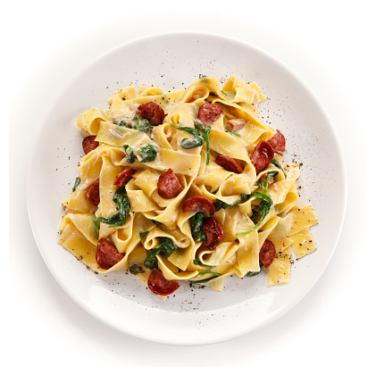 Pasta with meat and vegetables on white background