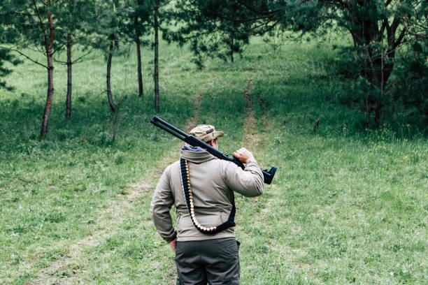 istock Hunter with a gun. Standing in the forest and waiting for prey 687714638