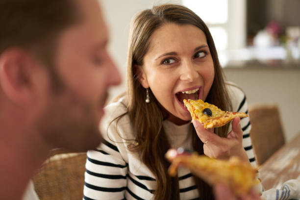 istock happy woman eating pizza 687716338