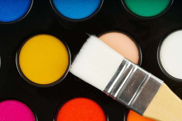 istock Colorful water color palette and a brush on black 687735686