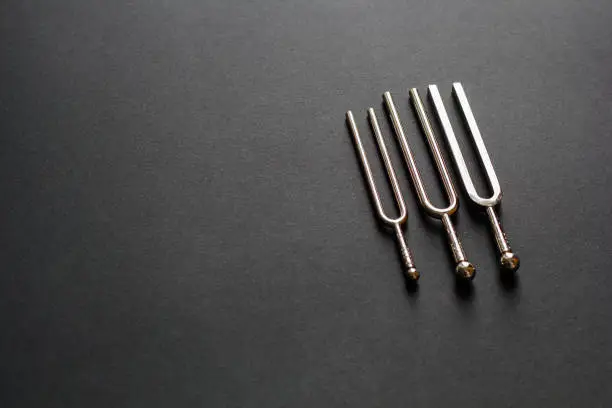 Three tuning forks on a black background
