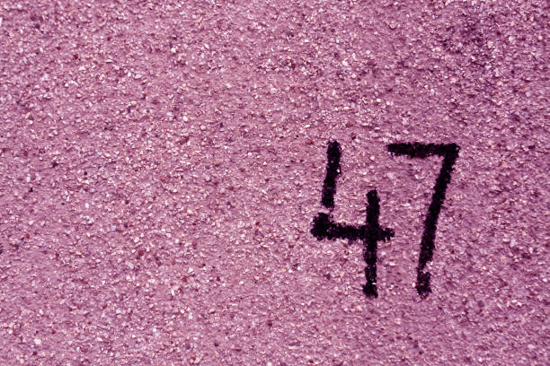 istock number fourty seven on purple plaster wall. 687750722