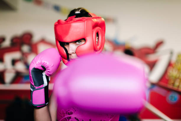 Woman boxer looking at camera Woman boxer serious in boxing ring looking at camera headwear stock pictures, royalty-free photos & images