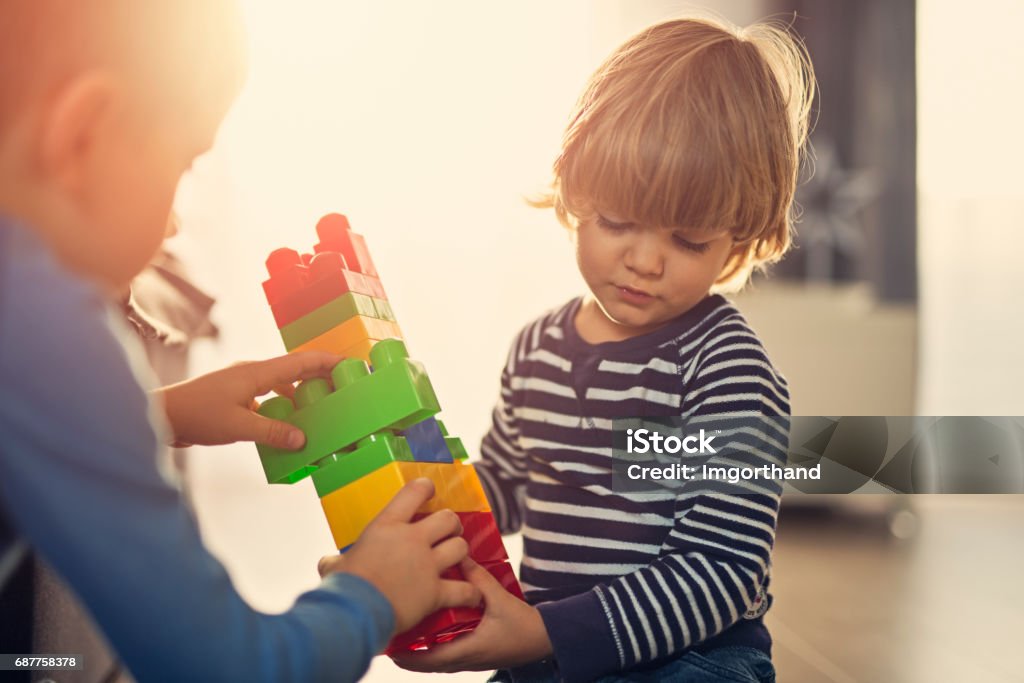 Meninos a brincar com os blocos no chão em casa - Foto de stock de Bloco de construção royalty-free
