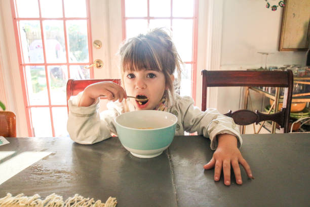 colazione - little girls small eating breakfast foto e immagini stock