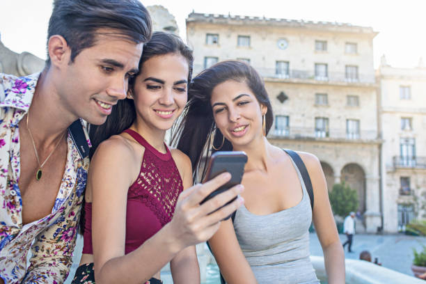 istock Young friends are using mobile phone in city 687758488