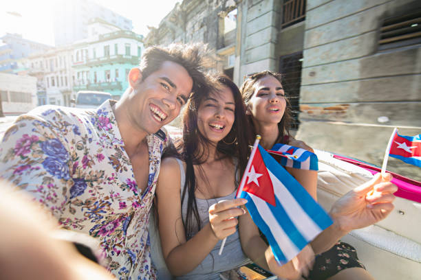 istock Young friends sitting in car with Cuban flags 687758512