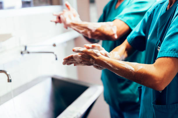 Couple of Surgeons Washing Hands Before Operating. Couple of Surgeons Washing Hands Before Operating. Hospital Concept. hygiene stock pictures, royalty-free photos & images